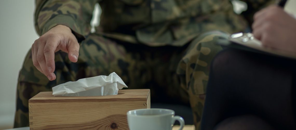 Close-up of a soldier's hand taking a tissue from a box during t